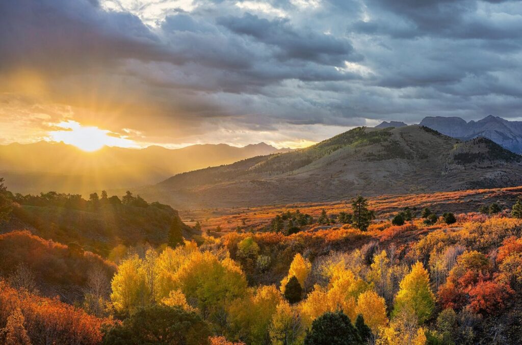Stunning autumn landscape with trees in the foreground and mountains in the background